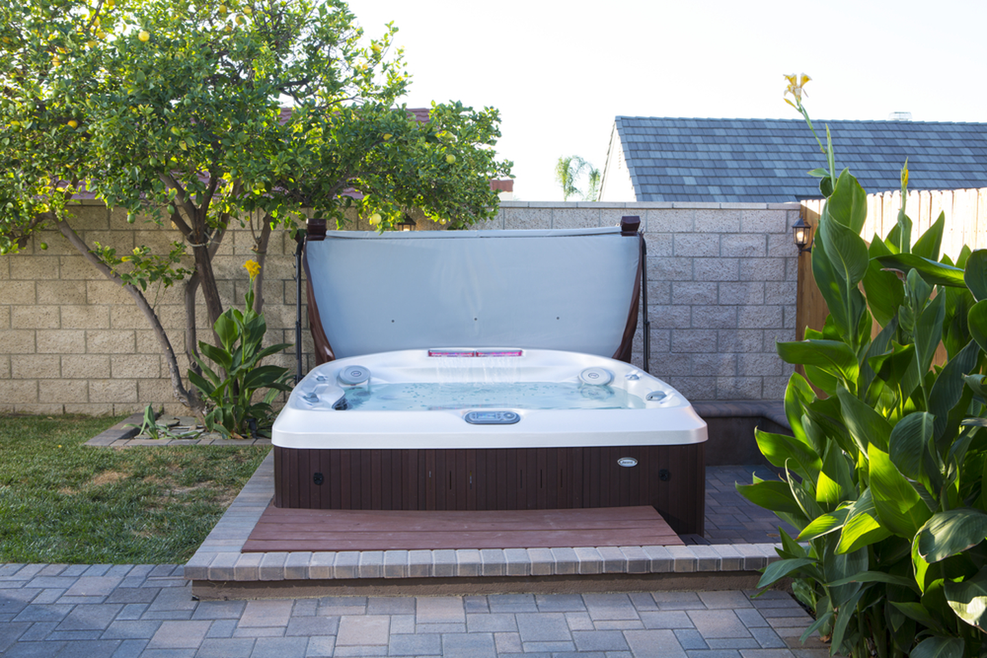 best rated hot tub brands - hot tub with cover in backyard