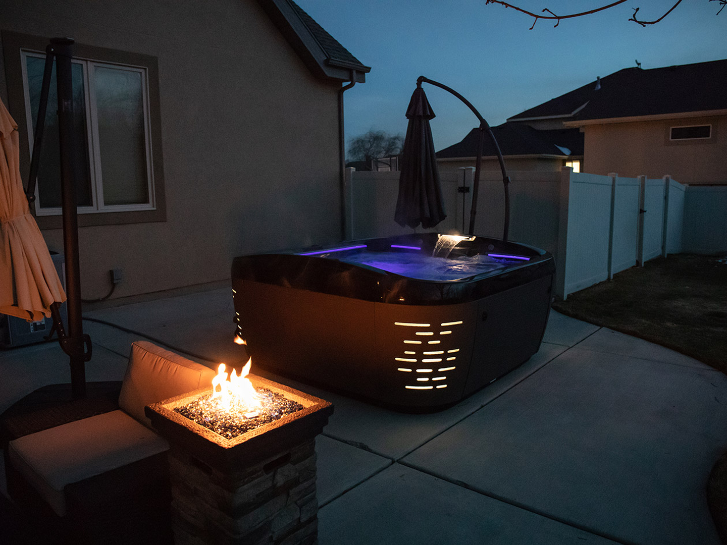 J-585 hot tub with firepit at night